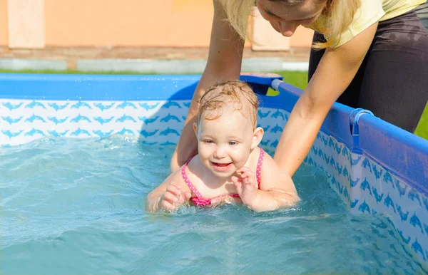 그녀의 딸 수영을 돕는 젊은 어머니 — 스톡 사진