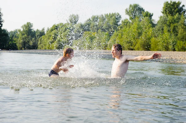 Młody ojciec i syn, pływanie w rzece — Zdjęcie stockowe