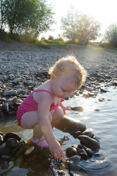 Bonito menina brincando com pedras — Fotografia de Stock