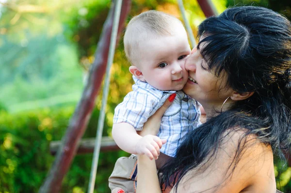 Jovem mãe beijando seu filho — Fotografia de Stock