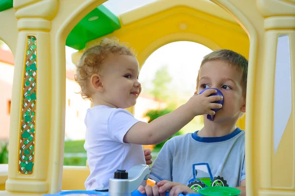 Linda niña alimentando a su hermano — Foto de Stock