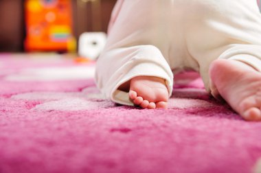 Baby crawling on pink carpet
