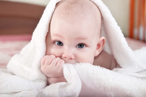 Baby onder witte handdoek — Stockfoto