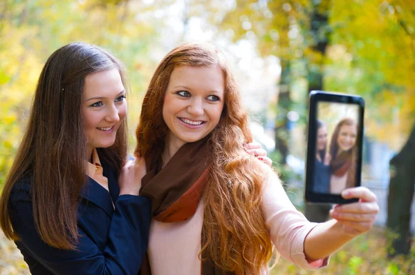 Two girls taking picture with digital tablet — Stock Photo, Image