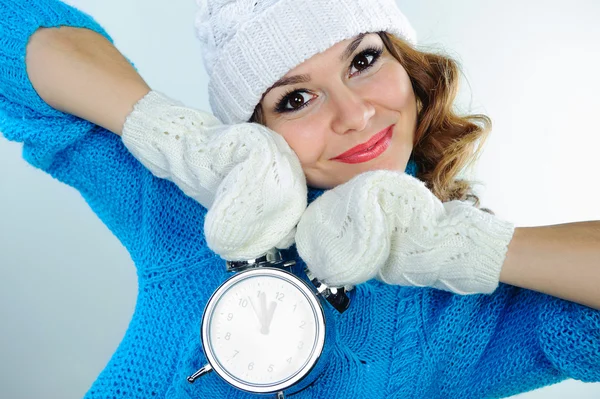 Молодая женщина в зимней одежде держит будильник — стоковое фото