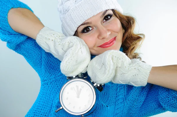 Jeune femme en vêtements d'hiver tenant réveil — Photo