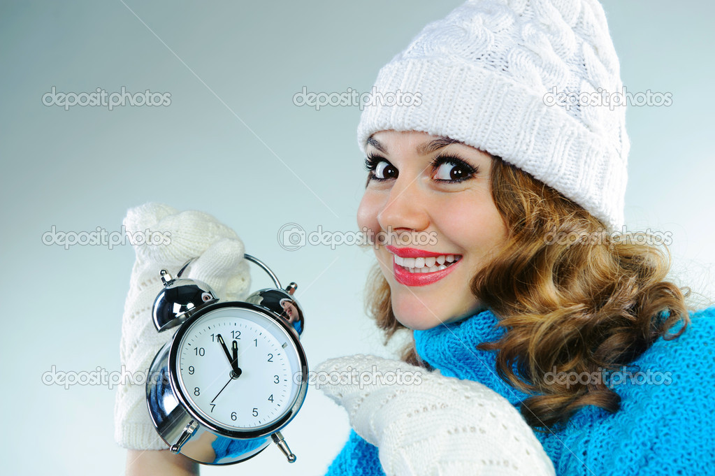 Young woman pointing on alarm clock