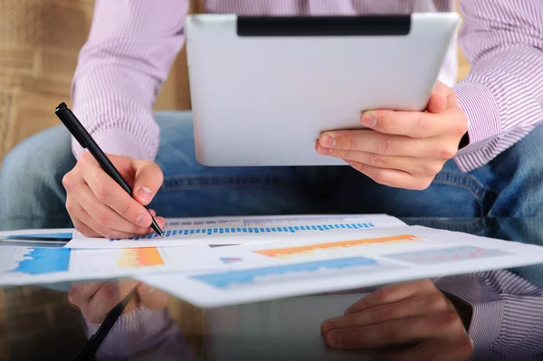 Jovem empresário analisando gráficos com tablet digital — Fotografia de Stock