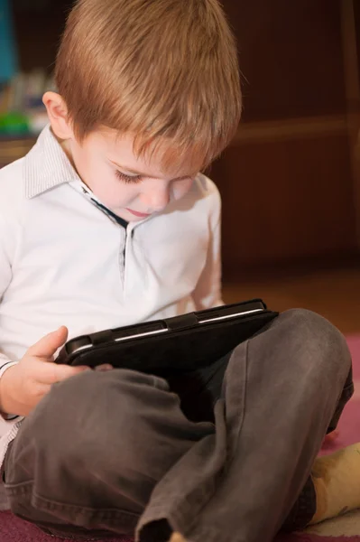 Netter kleiner Junge mit digitalem Tablet zu Hause — Stockfoto