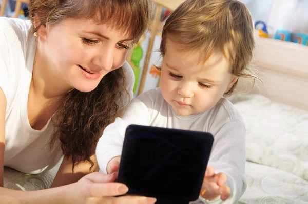 Мать и маленький сын играют с цифровым планшетом — стоковое фото