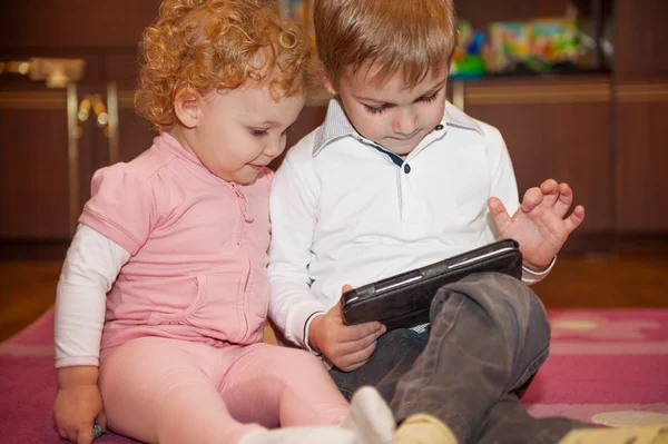 タブレットで遊ぶ 2 つのかわいい子供たち — ストック写真