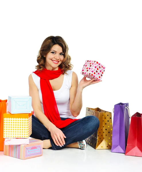 Chica joven en bufanda roja sentado con bolsas de compras aisladas en w —  Fotos de Stock