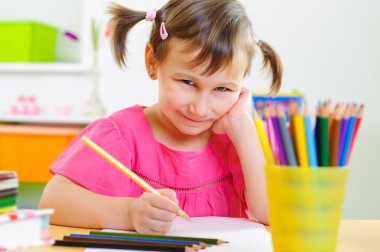 Güzel küçük kız evde ders çalışıyor.