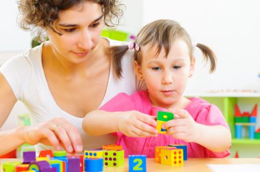 genç anne ve küçük kızı oyuncak bloklarla oynama