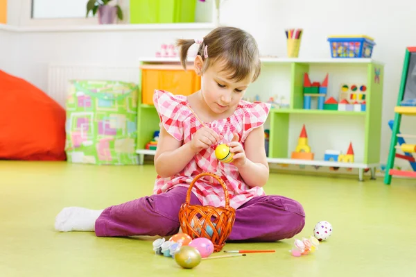 Klein meisje schilderij eieren voor paasvakantie — Stockfoto