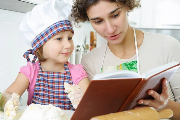 Jovem mãe com filhinha preparando biscoitos — Fotografia de Stock