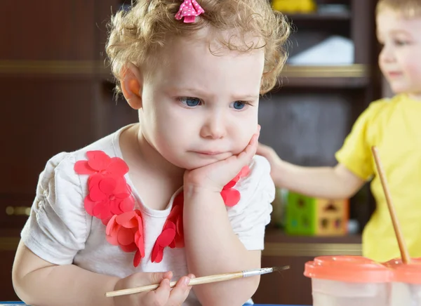 Thoughtful little girl with paintbrush — Stock Photo, Image