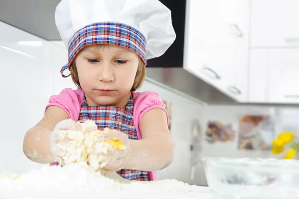 Liten flicka i baker hatt matlagning — Stockfoto