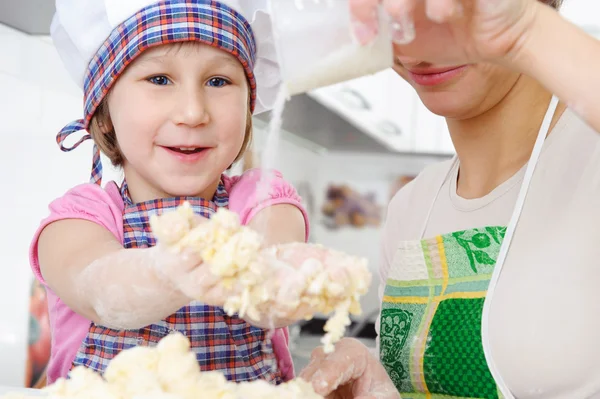 Little baker cooking in kitchen with mother — Stock Photo, Image