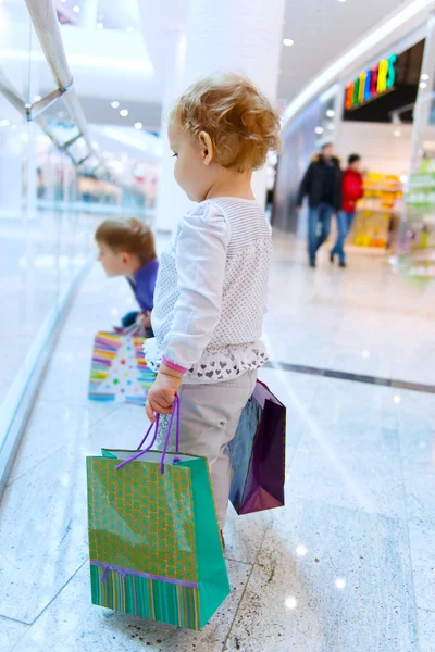 Children with bags in mall — Stock Photo, Image