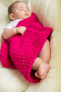 Yeni doğmuş bebek yatakta uyuyor.