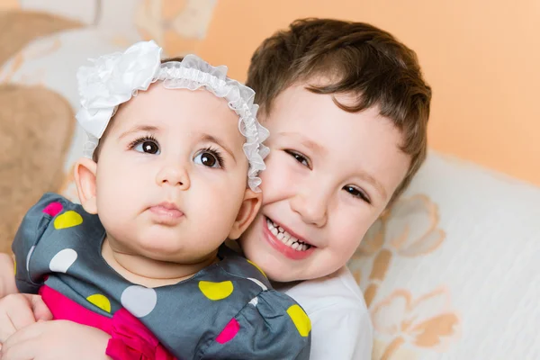 Older happy brother holding cute baby sister — Stock Photo, Image