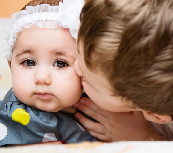Older brother kissing his baby sister — Stock Photo, Image