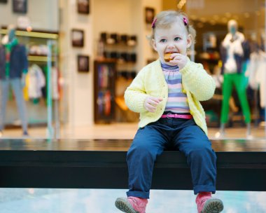 bankta bisküvi pasta yiyen sevimli küçük kız