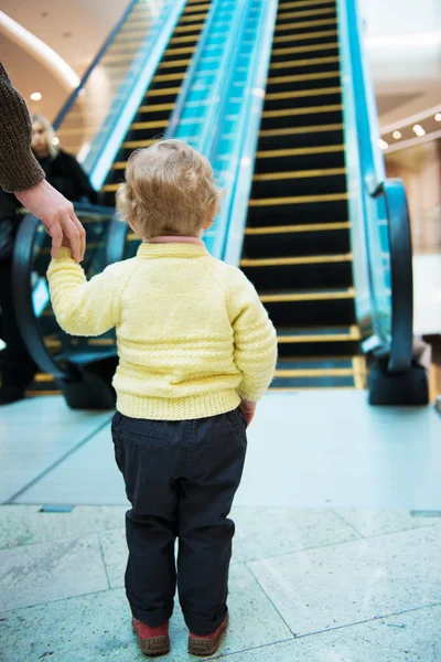 Liten flicka stående framför rulltrappa — Stockfoto