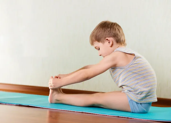 Malý chlapec, procvičení a protažení v tělocvičně — Stock fotografie