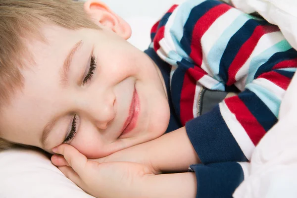 Kleiner süßer Junge schläft im Bett — Stockfoto