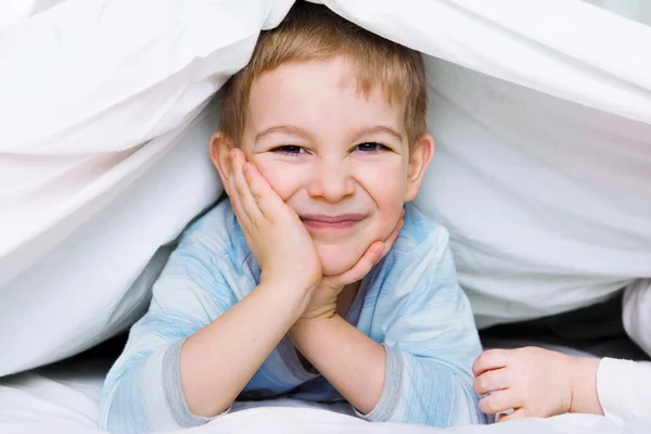 Schattige kleine jongen liggen onder deken — Stockfoto