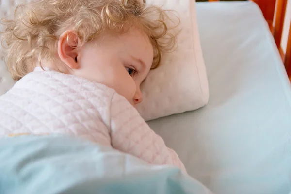 Kız hasta ve yorgun liying yatakta yastık üzerinde — Stok fotoğraf