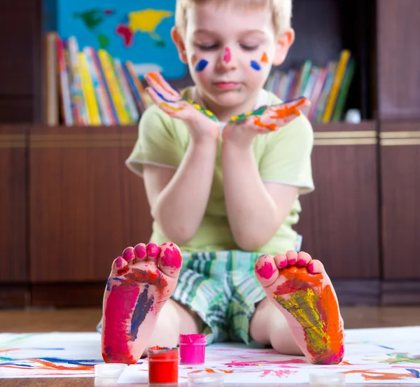 Jongen met kleurrijk geschilderde handen en voeten — Stockfoto