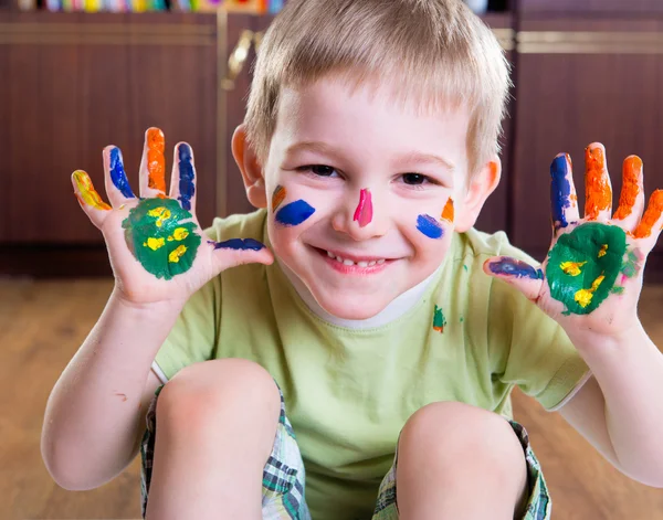 Menino feliz com mãos pintadas coloridas — Fotografia de Stock