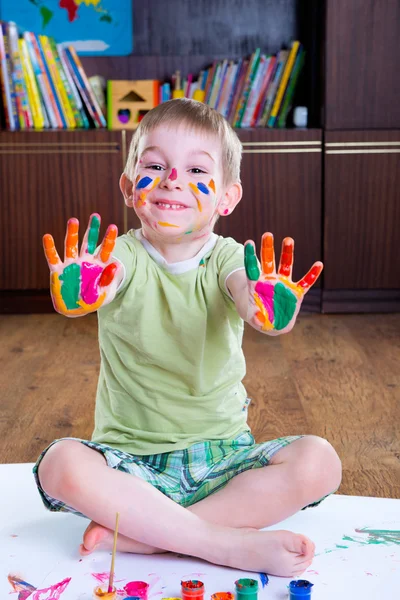 Schattige kleine jongen met zijn kleurrijke palmen — Stockfoto