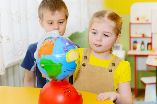 Crianças pequenas estudar globo — Fotografia de Stock