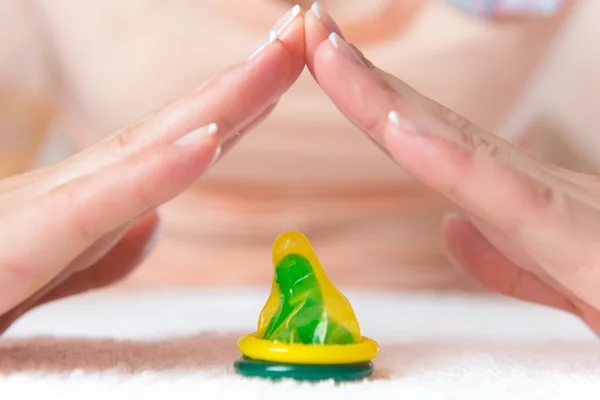 Womans hands doing roof above condom — Stock Photo, Image