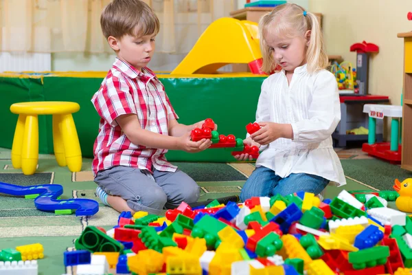 Двое детей играли с блоками на полу — стоковое фото