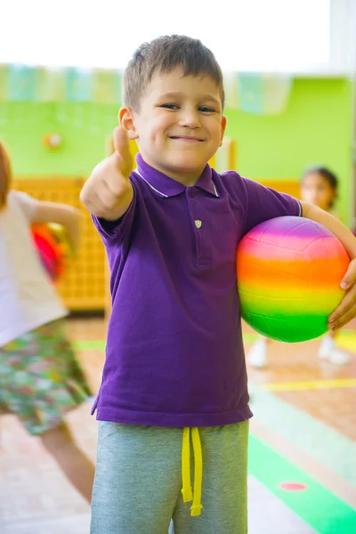 Ładny mały chłopiec bawi się w siłowni przedszkola — Zdjęcie stockowe
