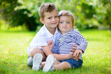 Mutlu kız ve erkek kardeş parkta birlikte.