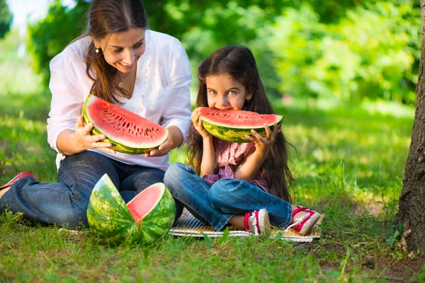 Familia hispana feliz comiendo sandía — Foto de Stock