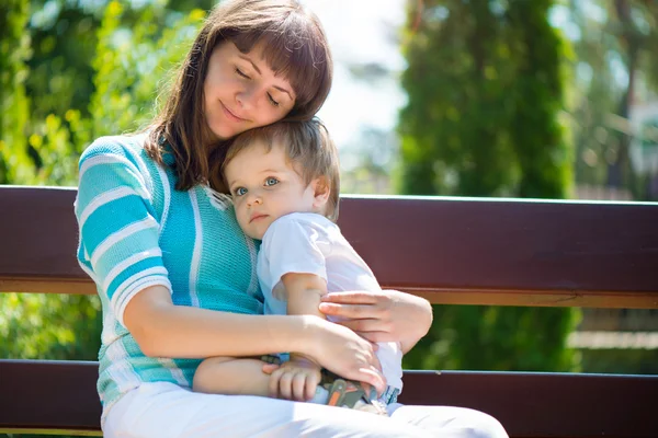 Young mother with her son in park Stock Photo