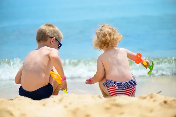 Little brother and sister playing with sand — Stock Photo, Image