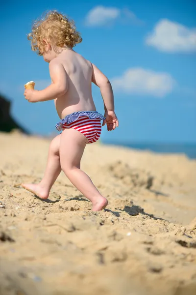Симпатична маленька дитина біжить на океанічному пляжі — стокове фото