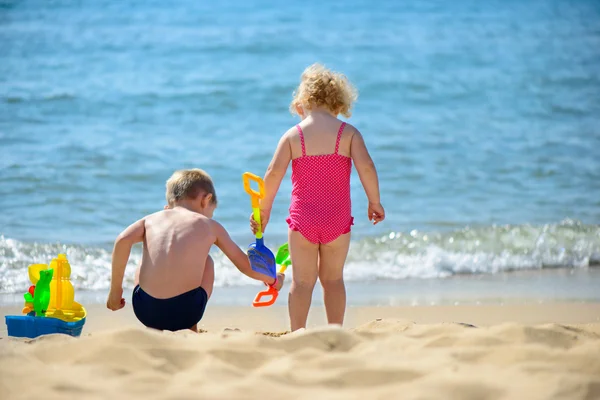 Little brother and sister playing with sand — Stock Photo, Image