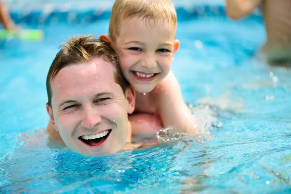 Jovem pai e filho nadando na piscina — Fotografia de Stock