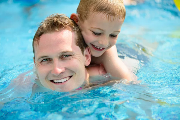 Jovem pai e filho nadando na piscina — Fotografia de Stock