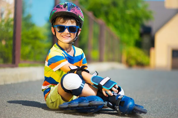 Cute little boy in sunglasses with rollers — Stock Photo, Image