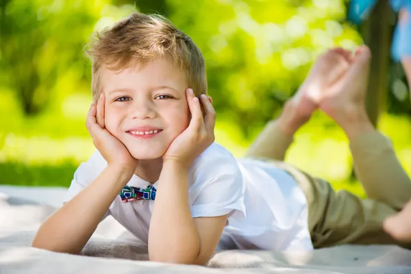 sevimli küçük çocuk ile kelebek yeşil çim üzerinde yalan